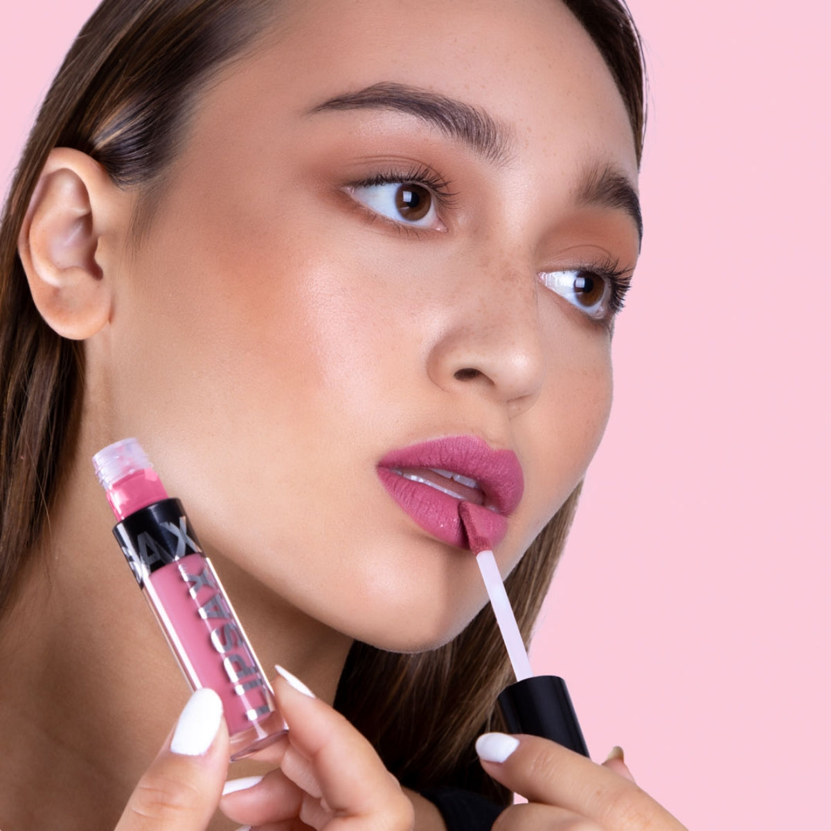 Model applying LIPSAX to her lips in the shade Selfie, A light pinkish nude