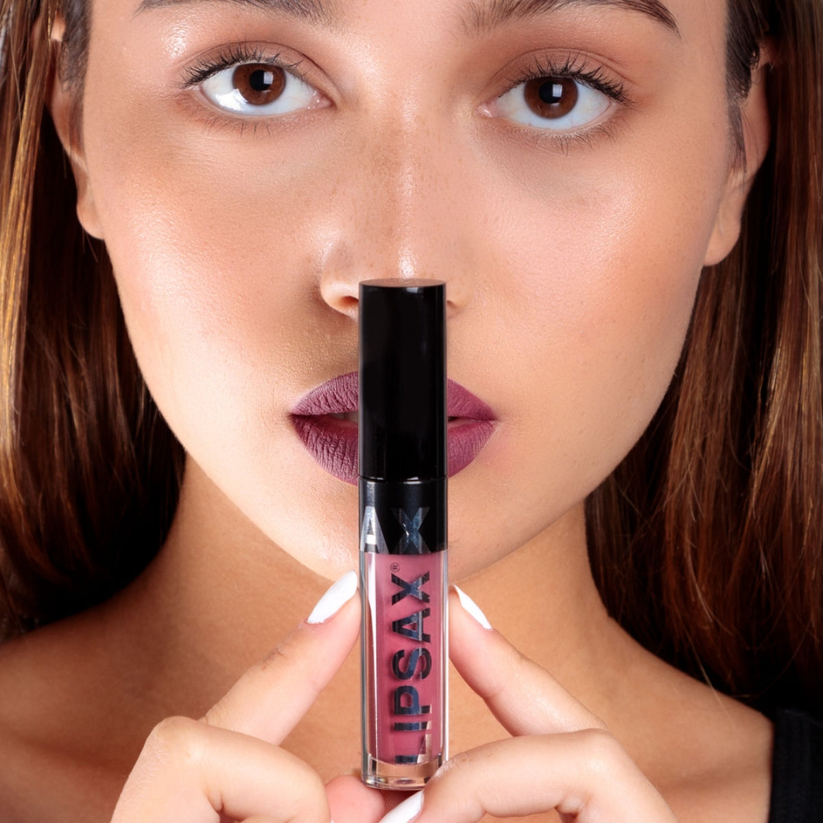 A model holding LIPSAX in front of her lips